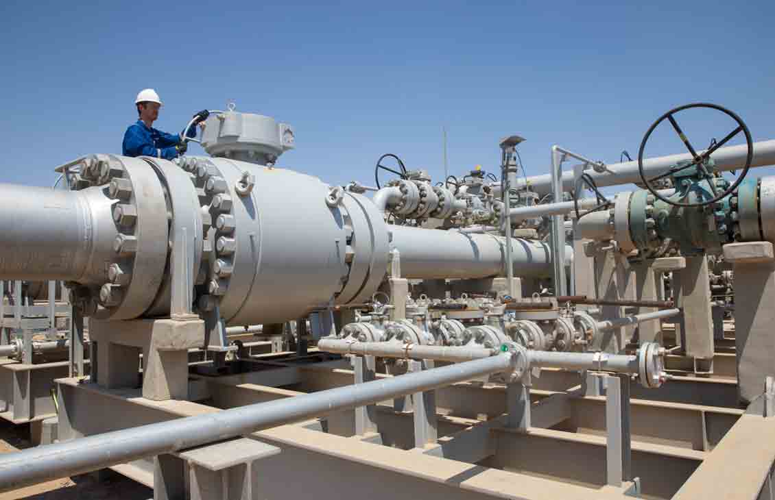 Photo of person in blue coveralls working with pipeline equipment (Sabriya GROVE Manual Inlet Valve with Person)
