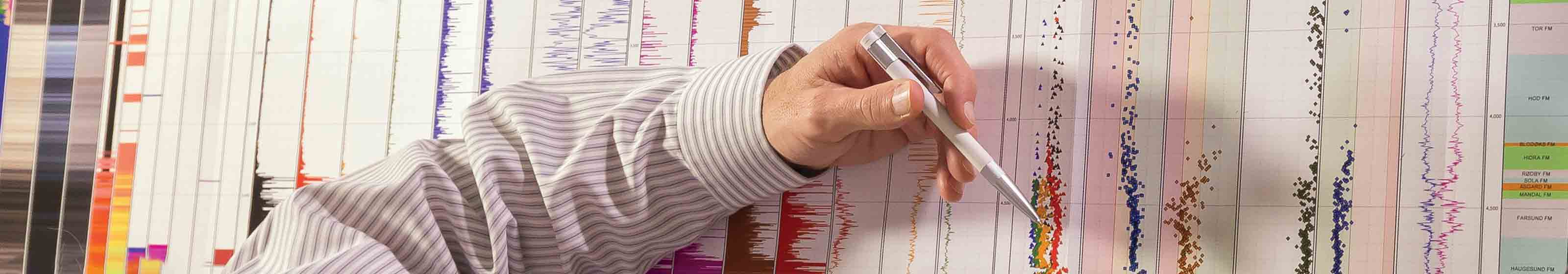 Schlumberger worker's arm pointing to cuttings analysis data.