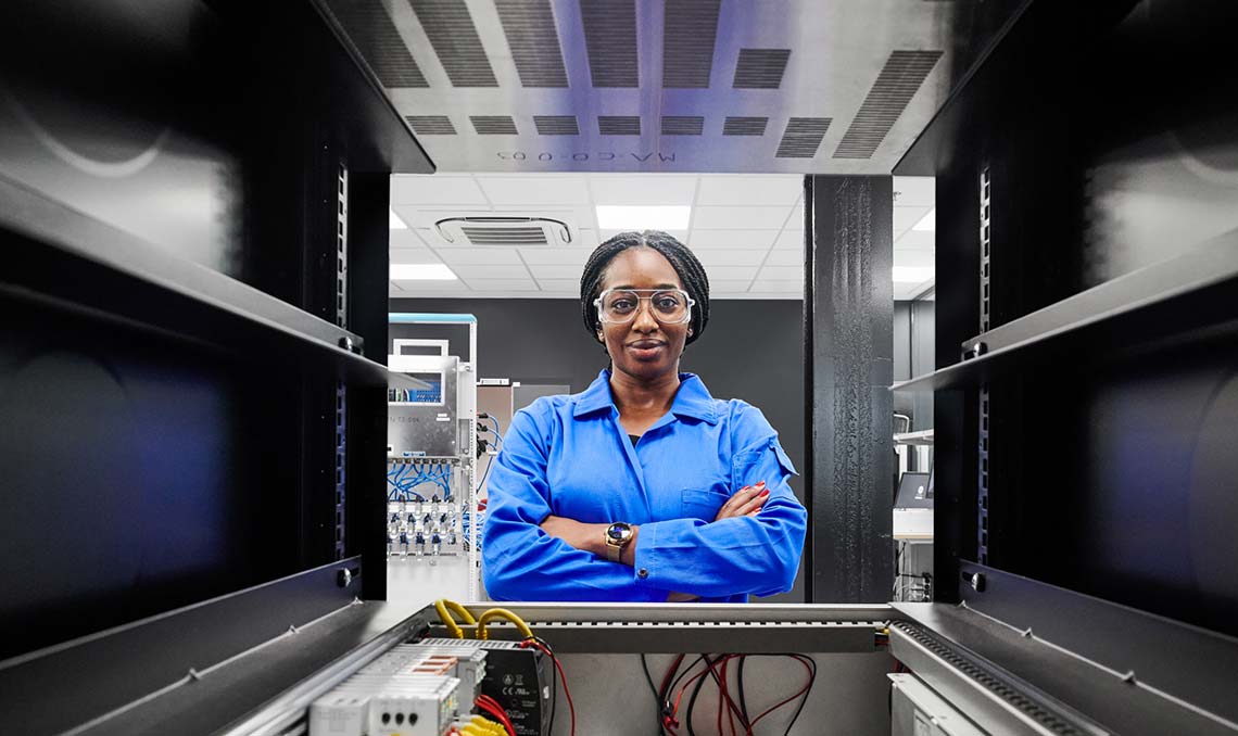 Female engineer looking through a piece of equipment (Tier 1_Lab_Clamart_OAT_0861)