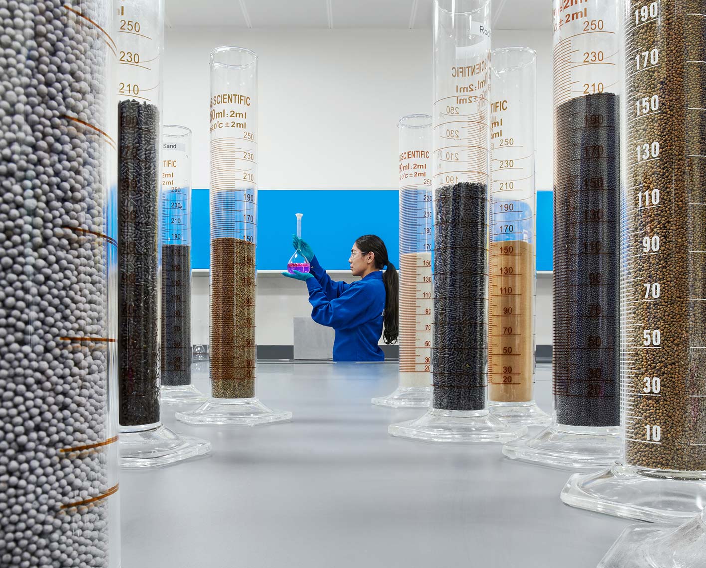 Female engineering looking at beakers with solid samples in a Learning Center, Abu Dhabi (Tier 1_LearningCenter_Abu Dhabi_MENA_ 8628)